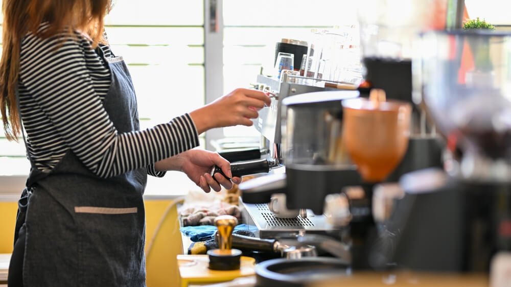 mulher barista preparando o café